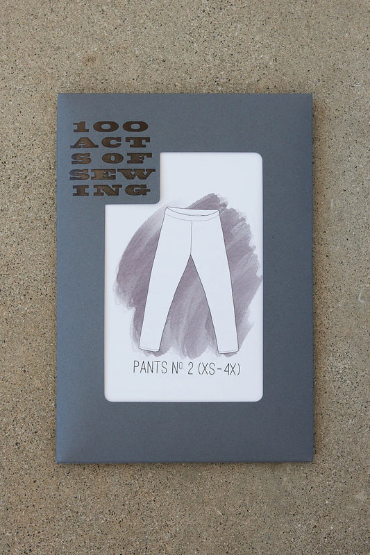Booklet titled '100 Acts of Sewing' with an illustration of pants on a textured surface