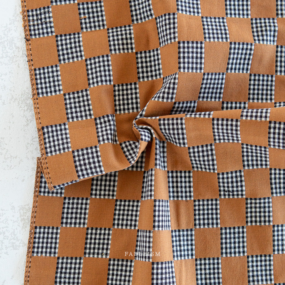 Checkered fabric with light brown and black and white pattern.