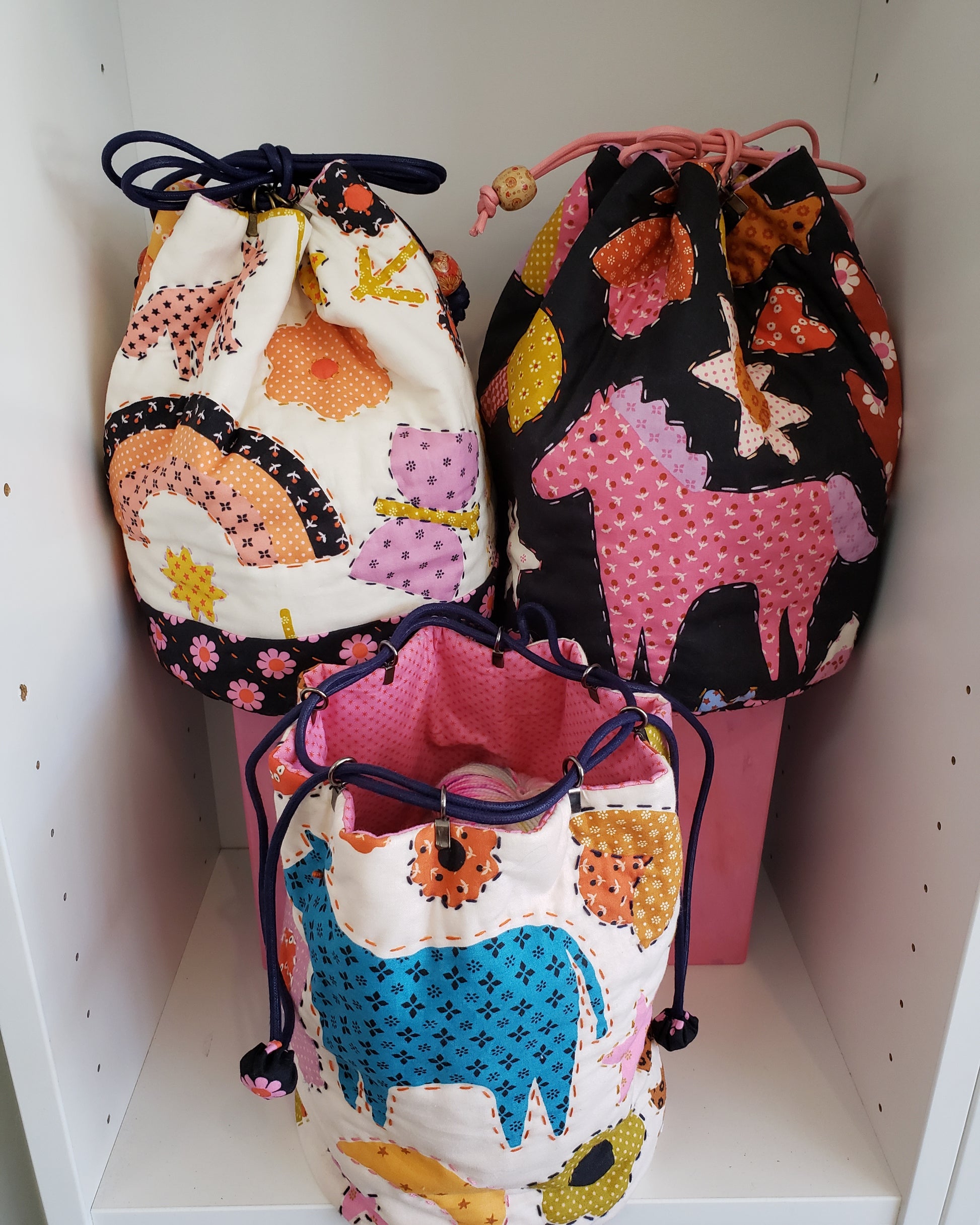 3 drawstring rice bag pouches with big stich embroider around the designs