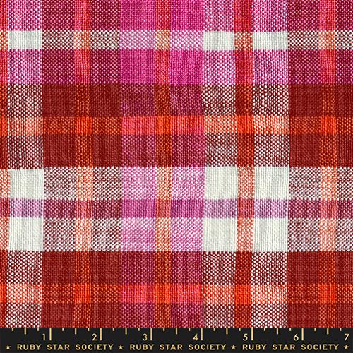 Plaid fabric with red, pink, and white pattern, featuring a ruler at the bottom.
