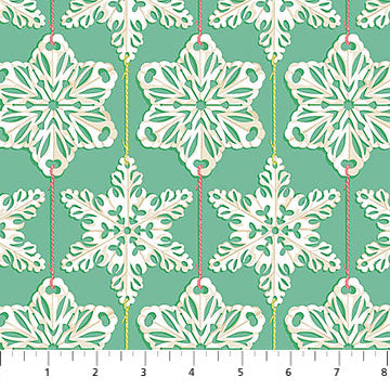 Pattern of white snowflakes with red strings on a teal background, with a ruler at the bottom.