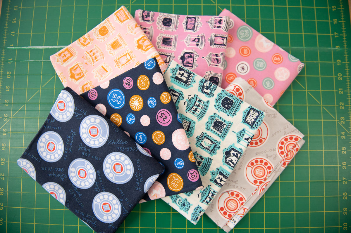 Collection of patterned fabric squares on a green cutting mat