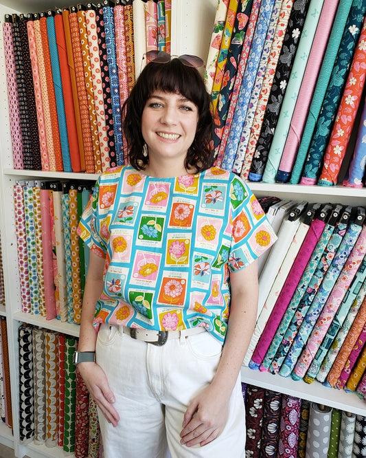 A person wearing a boxy top with flowers