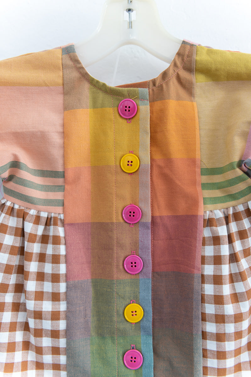 Colorful patchwork dress with buttons on a white background
