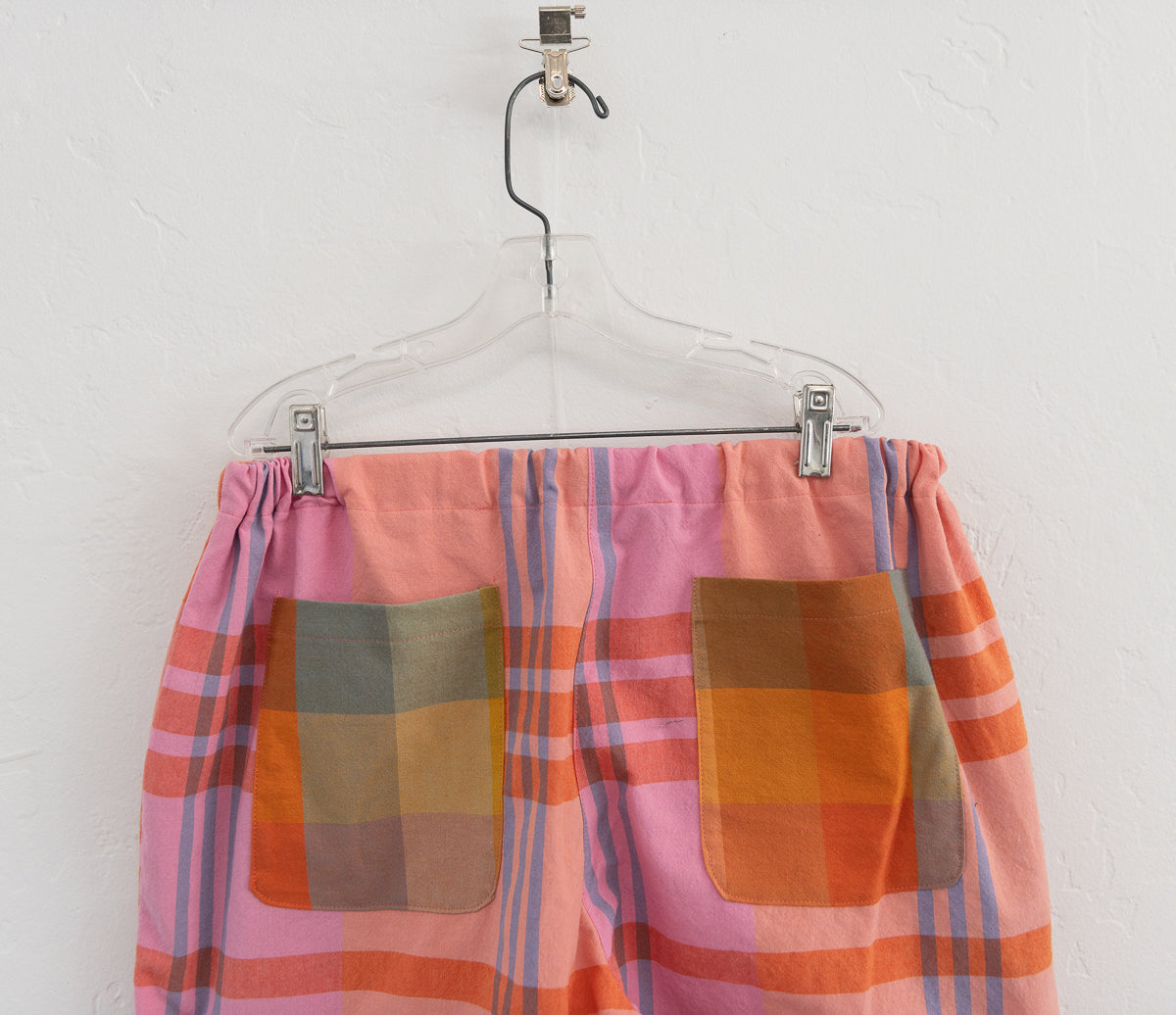 Plaid skirt with colorful pattern on a hanger against a white background