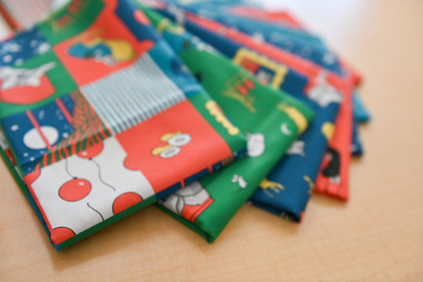 Stack of colorful Goodnight Moon themed fabric on a wooden surface