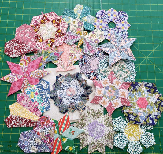 Colorful star-shaped fabric pieces on a green cutting mat