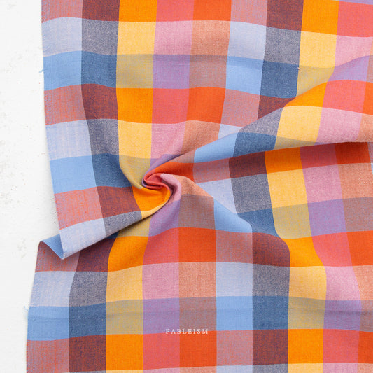 Multicolored checkered fabric with 'Fableism' branding on a white background