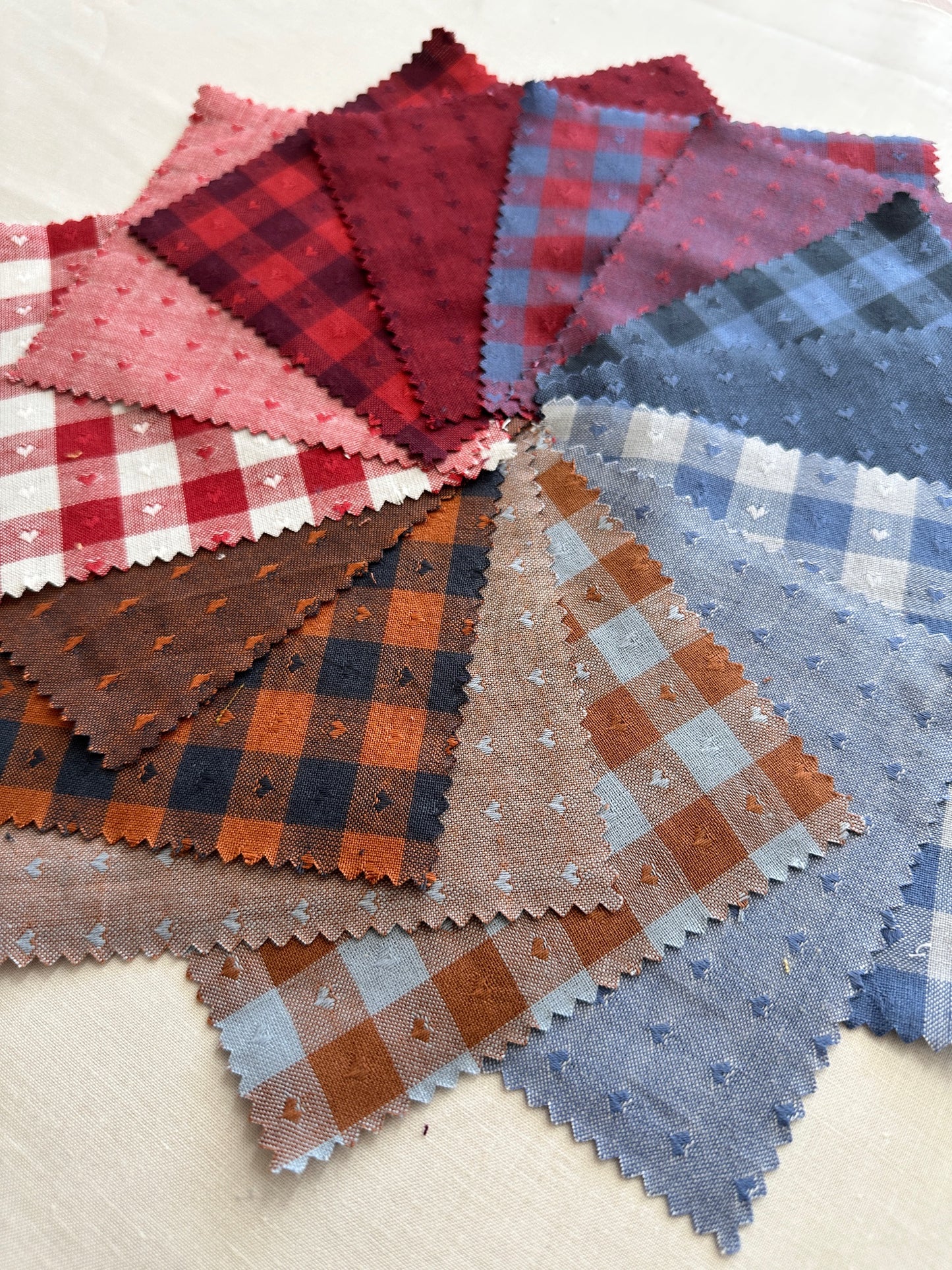 Queen of Hearts fabric close up featuring red, blue, brown and white fabric with checkered prints and tiny hearts
