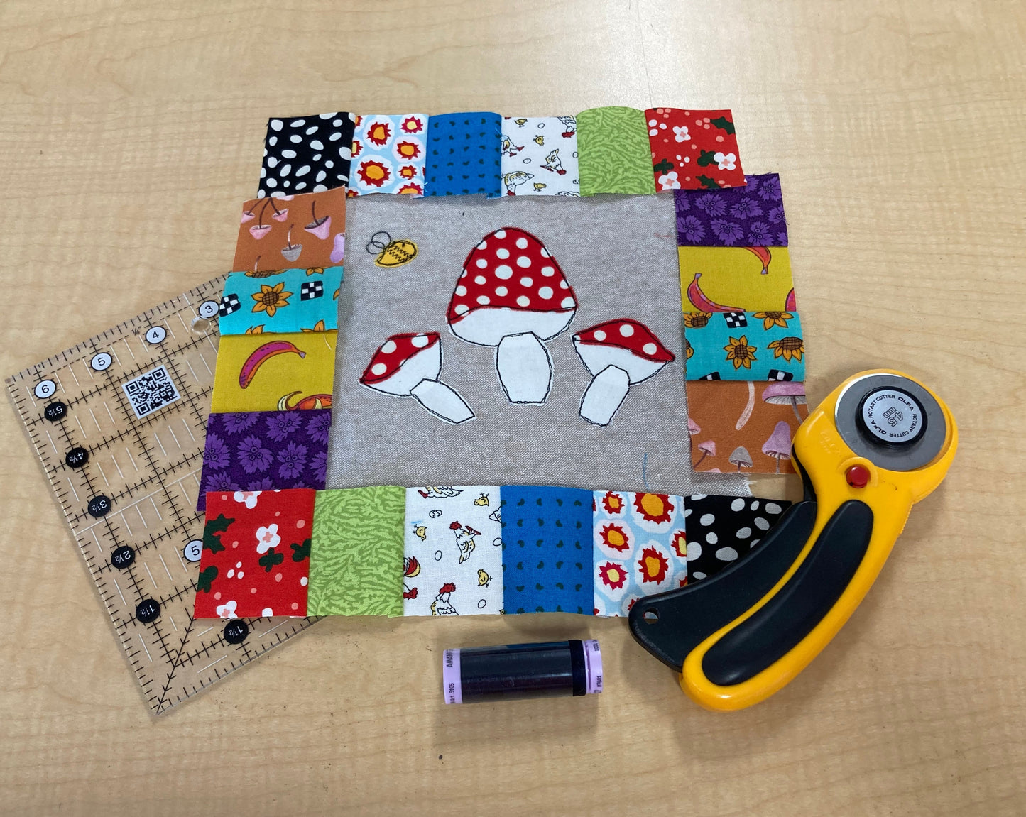 quilt block in progress with mushrooms, bee and patchwork borders