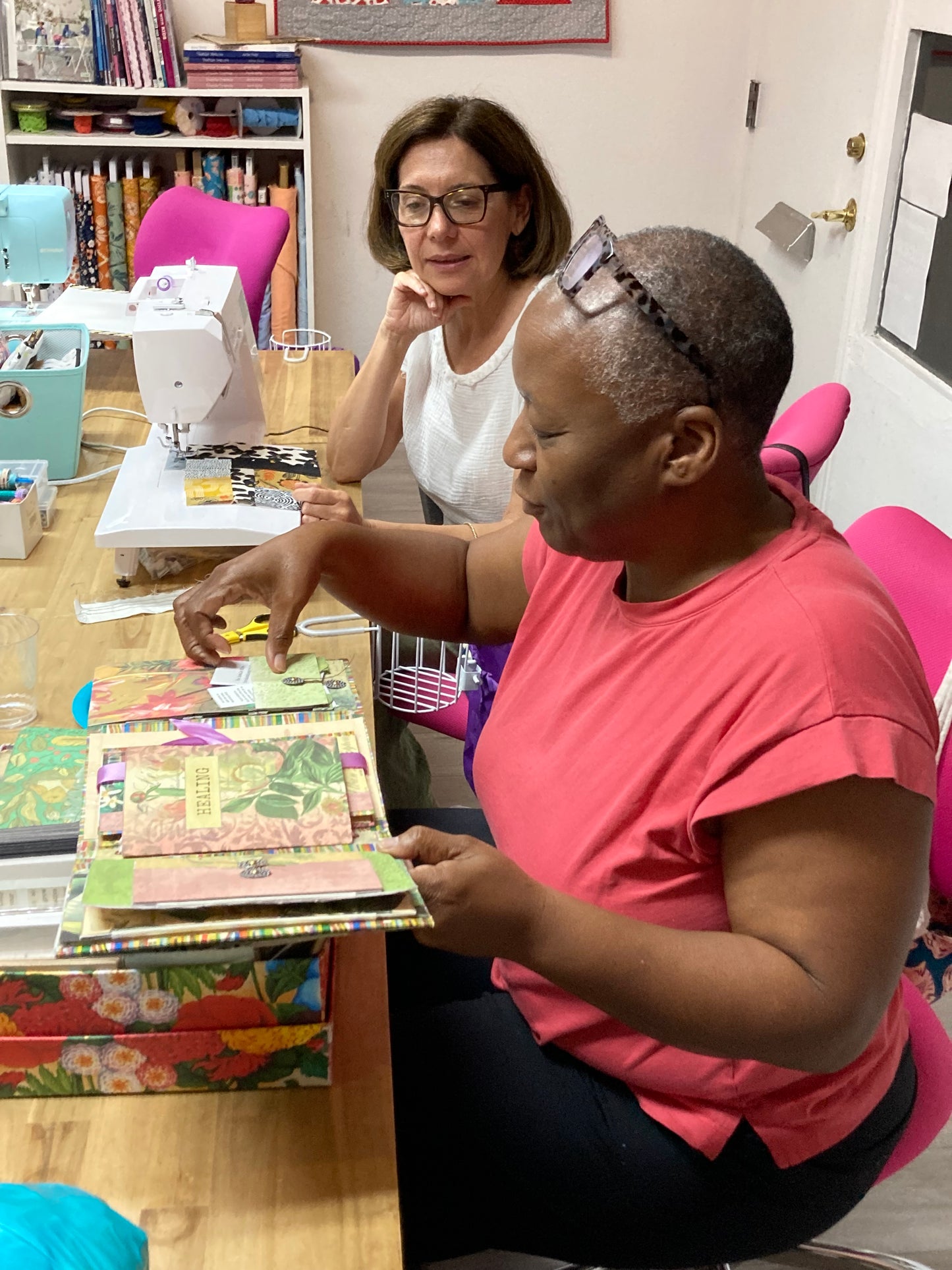 a brown skinned woman is working on a colorful scrap journal