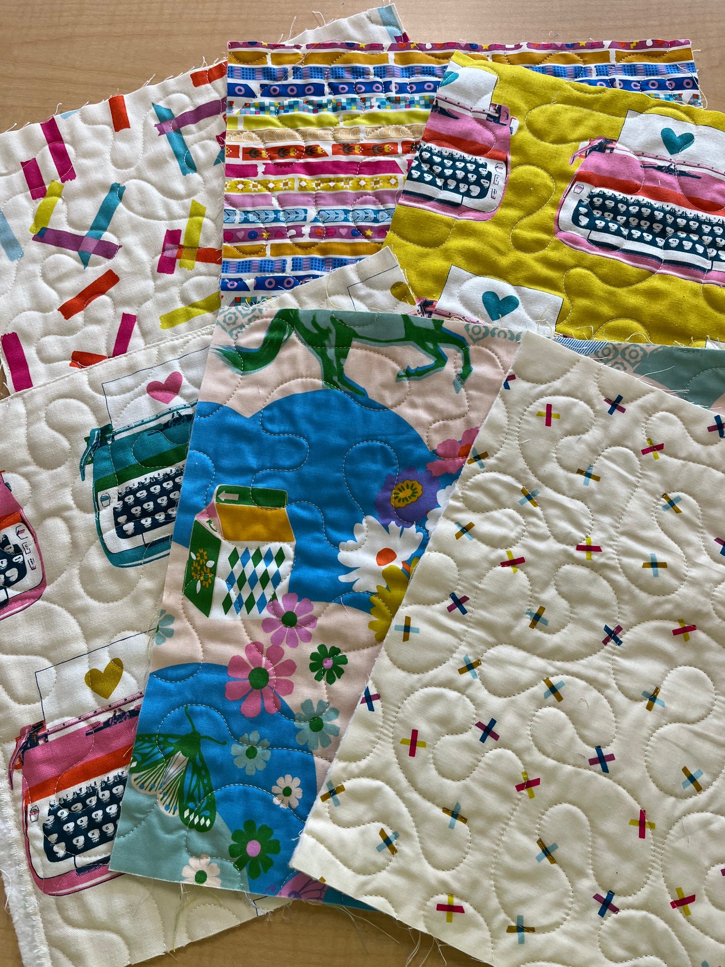 Colorful quilt with typewriter and floral patterns on a wooden surface