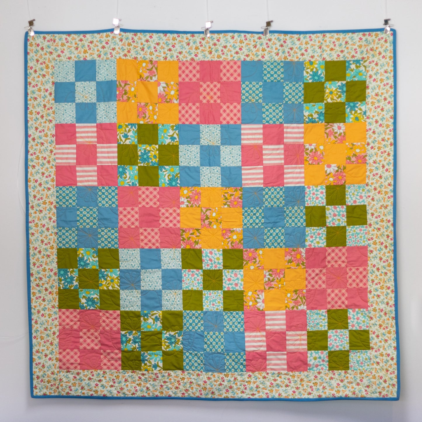 Colorful patchwork quilt with a geometric pattern on a white background