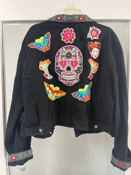Black jacket with colorful patches including a skull design on a white background