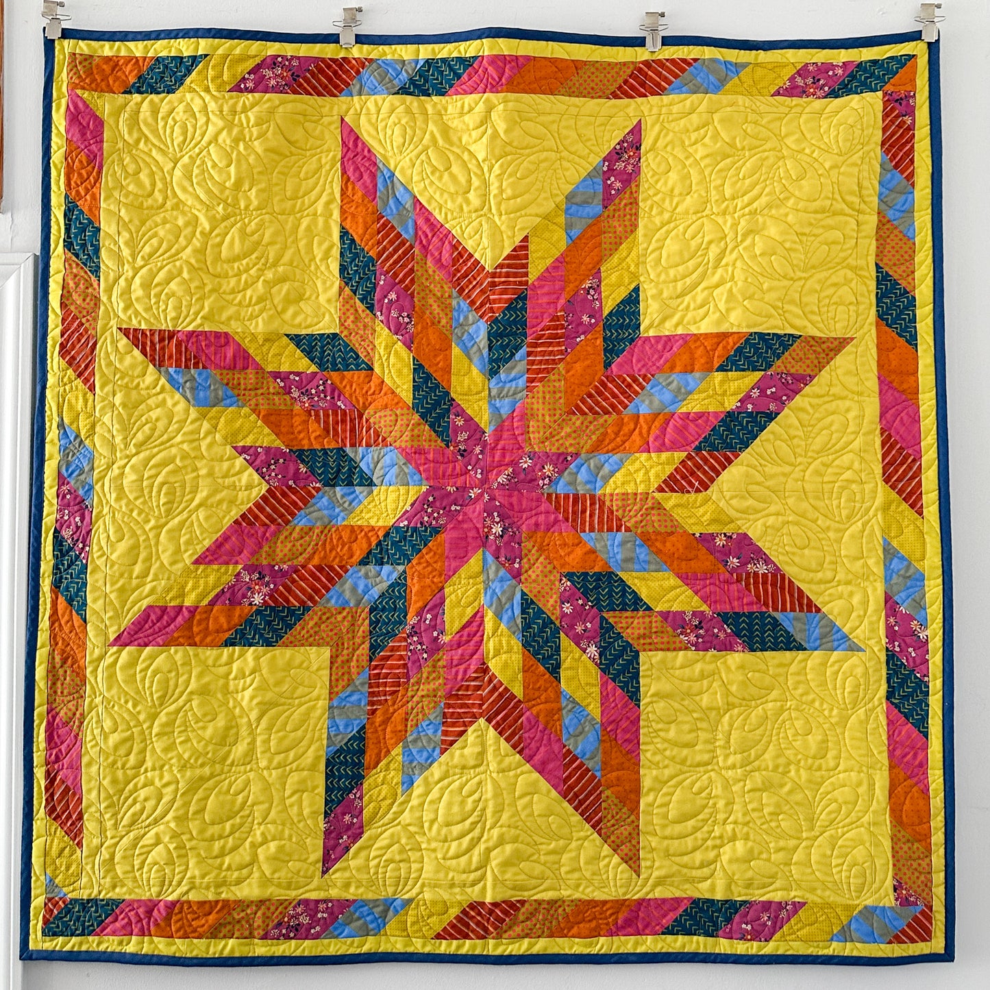 Colorful quilt with star pattern on a white background
