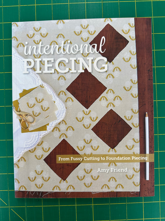 Book titled Intentional Piecing on a green cutting mat