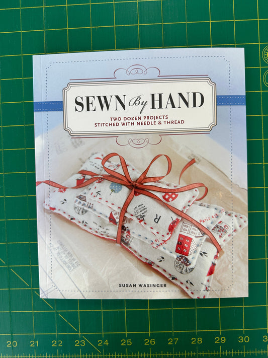 Book titled Sewn by Hand on a Green Cutting Mat