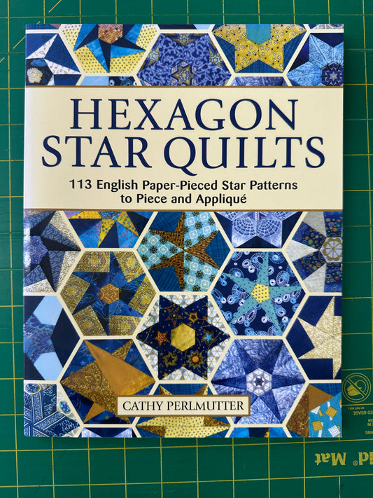 Book cover of 'Hexagon Star Quilts' with star and hexagon pattern on a green cutting mat background.