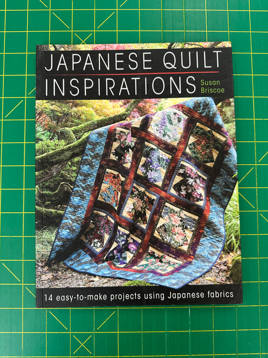 Book titled 'Japanese Quilt Inspirations' on a green cutting mat with quilt pattern