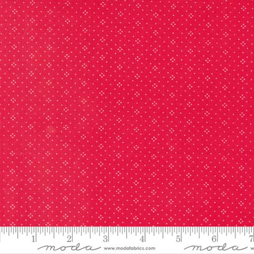 Red fabric with small white dot pattern and a ruler at the bottom