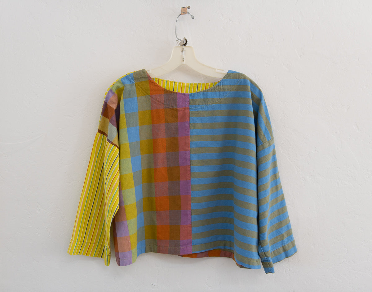 Colorful plaid shirt on a hanger against a white background