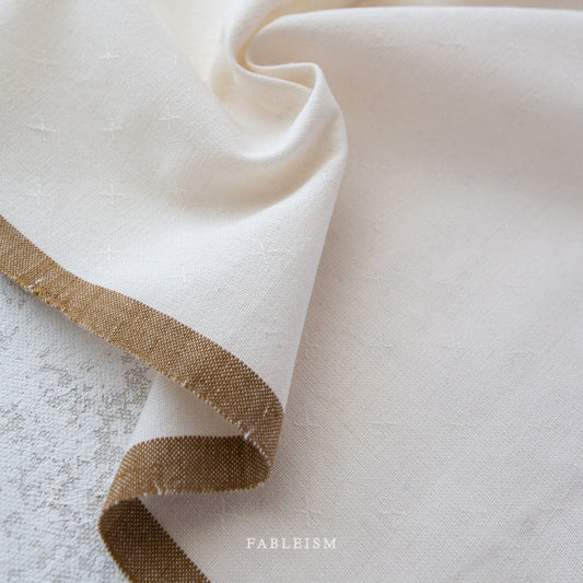 White fabric with a light brown border