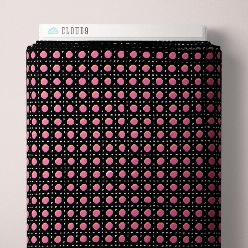 Black bolt of fabric with pink polka dots and white label on a light gray background