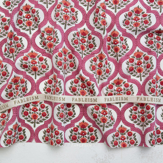 Patterned fabric with red floral design and 'Fableism' branding.