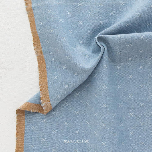blue textured fabric with a brown border
