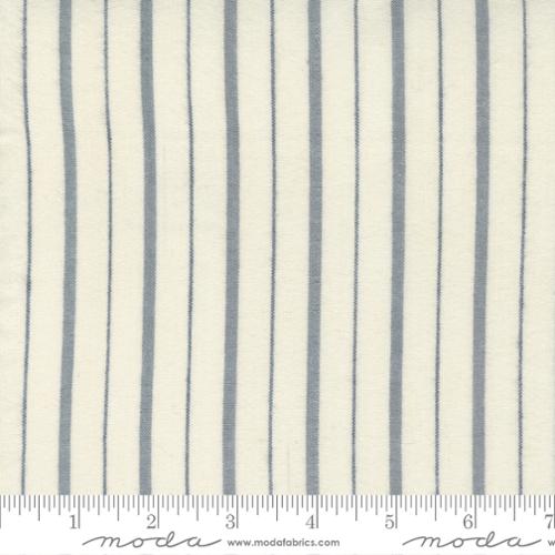 Fabric with blue vertical stripes on a white background, featuring Moda label.