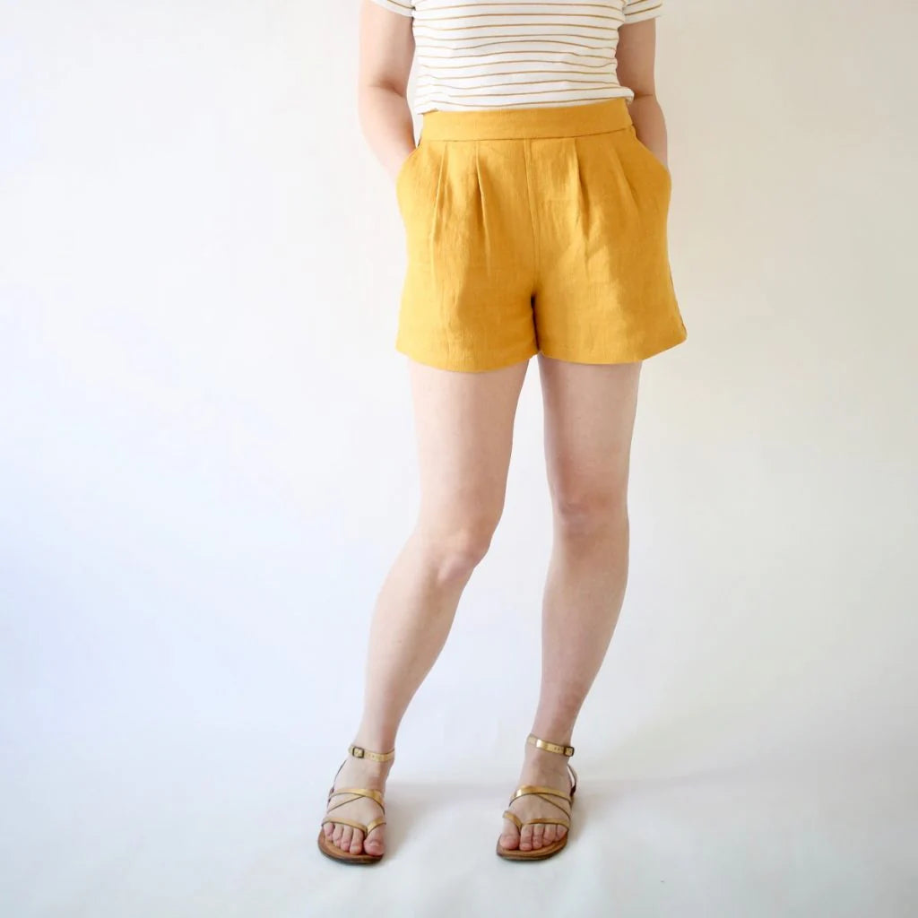Person wearing mustard yellow shorts on a white background