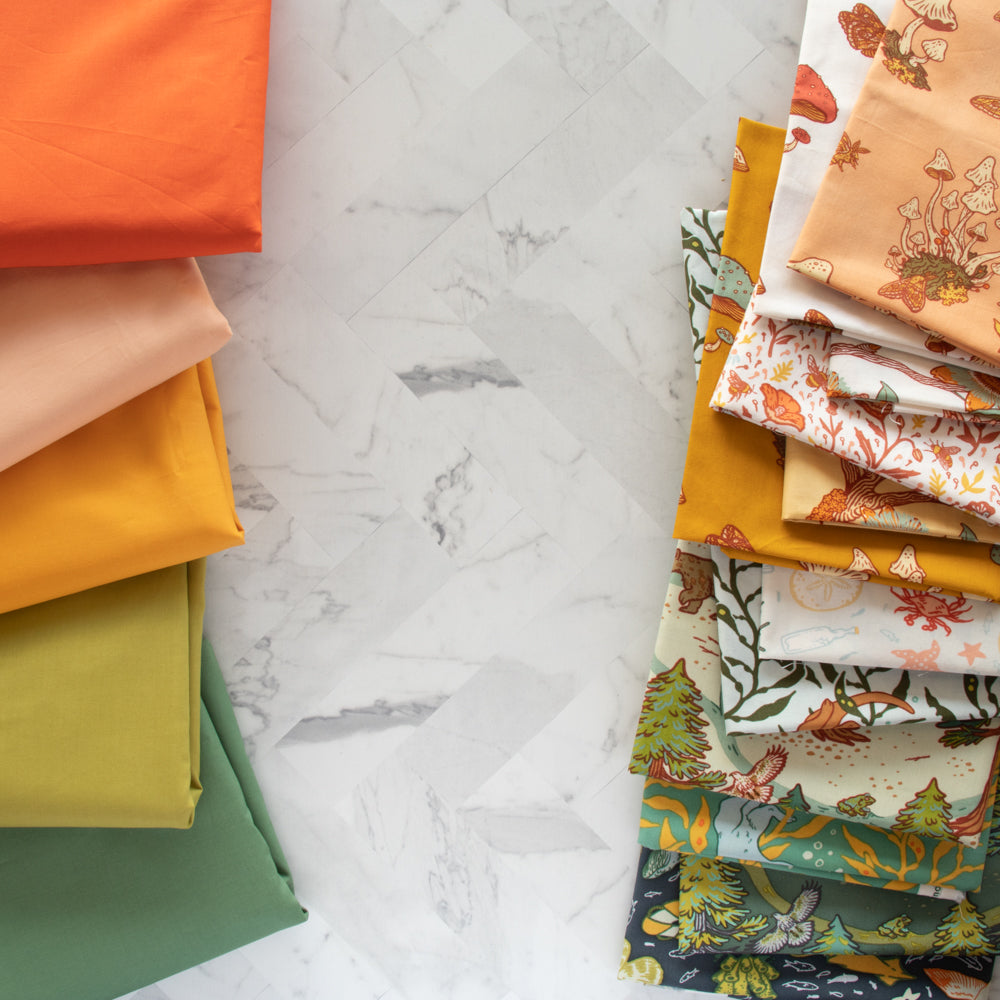 a bundle of orange, yellow and green fabrics