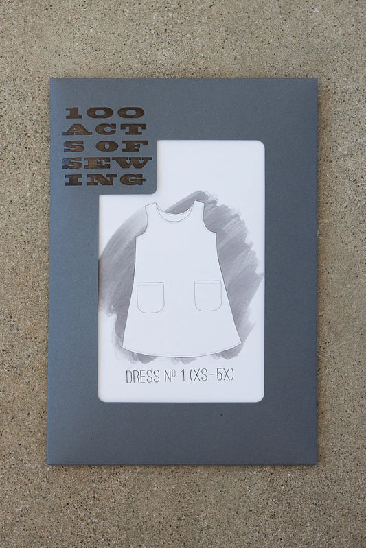 A packaged sewing pattern for Dress No. 1 with the brand name 100 Acts of Sewing visible on the cover.