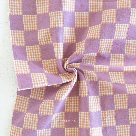 Checkered fabric with purple and peach pattern on a white background