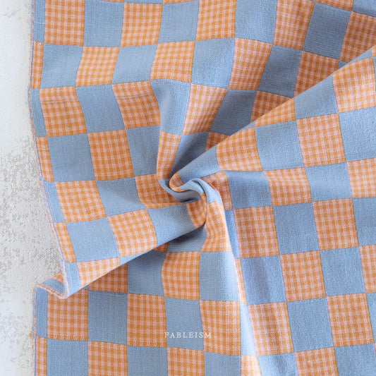 Checkered fabric with orange and blue pattern.