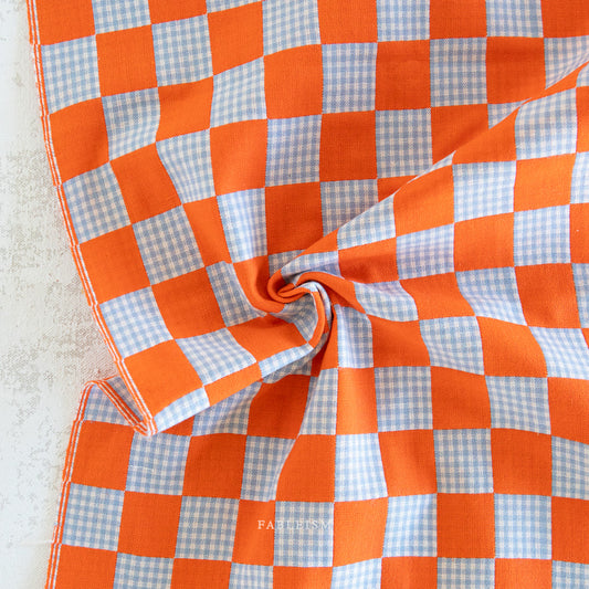Checkered fabric with bright orange and pastel blue pattern 