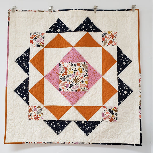baby quilt ivory with blue and orange triangles