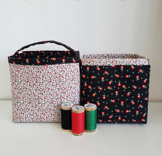 2 fabric boxes side by side, one slightly smaller, in black red and cream. 