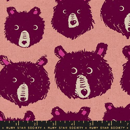 a close up of light pink fabric with dark pink bear faces 