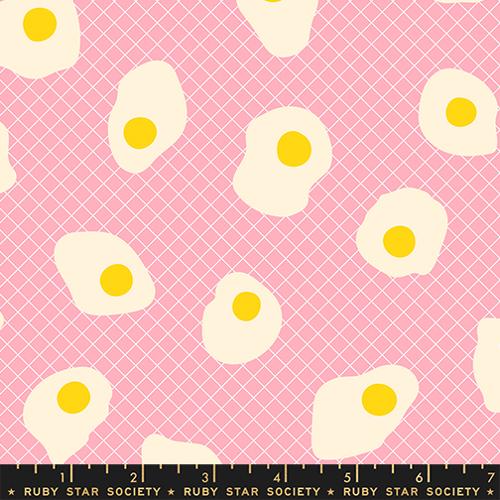 Pattern of fried eggs with yellow yolks on a pink background, featuring a ruler at the bottom.