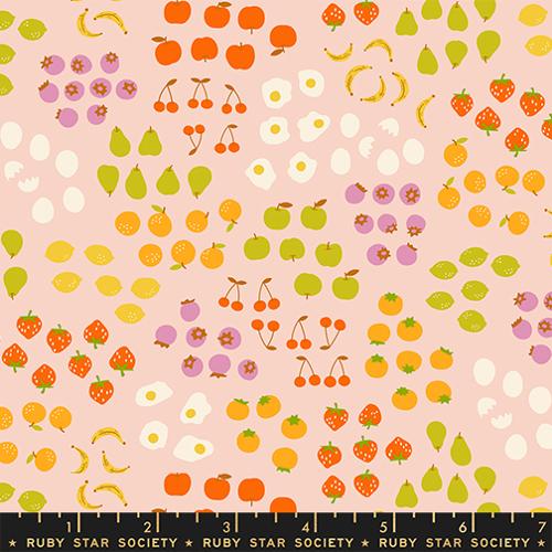 Patterned fabric with fruits and vegetables on a pink background, featuring a ruler at the bottom.