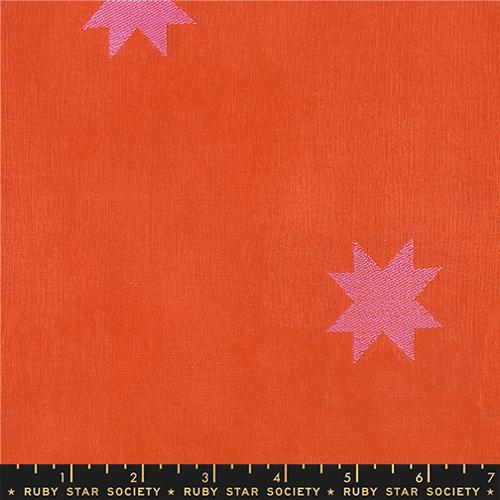 Fabric with pink stars on an orange background, featuring Ruby Star Society label.