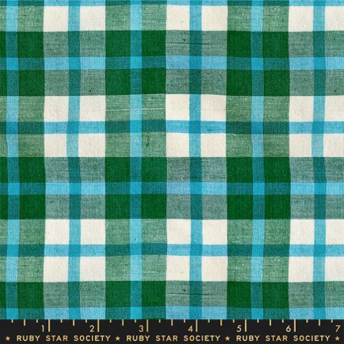 Plaid fabric with green, blue, and white pattern, featuring a ruler at the bottom.