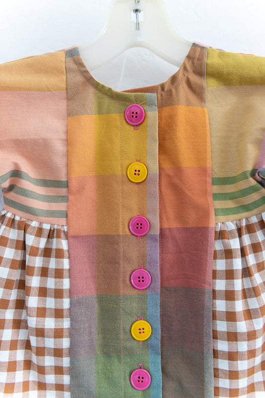 Colorful patchwork dress with buttons on a white background