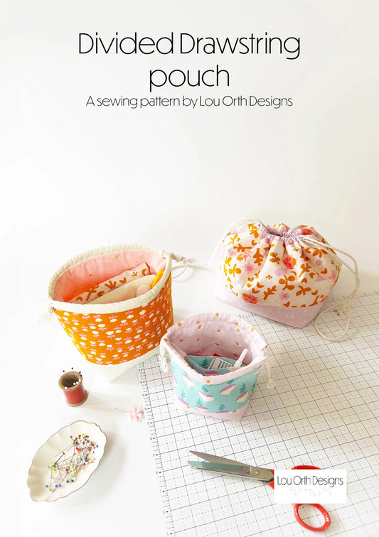 Divided drawstring pouch sewing pattern by Lou Orth Designs with fabric samples and tools on a grid background.