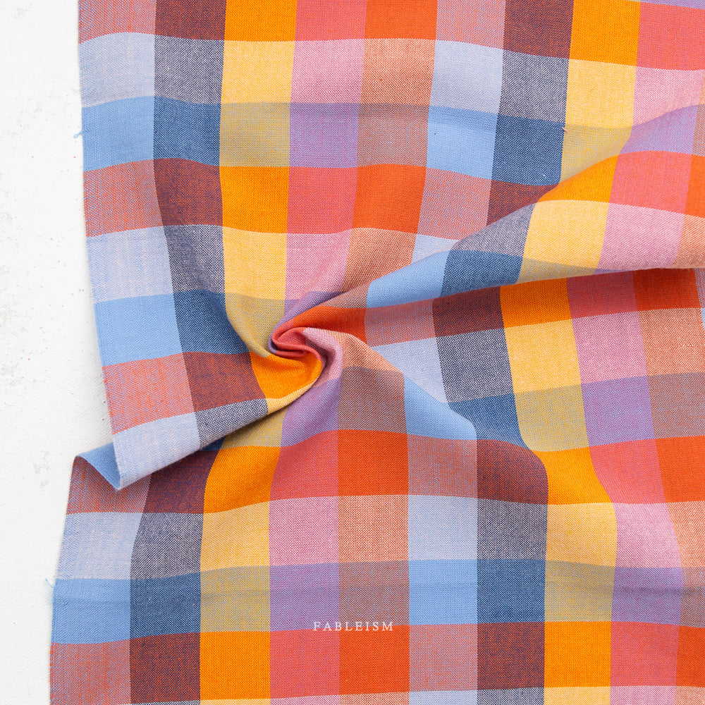 Multicolored checkered fabric with 'Fableism' branding on a white background