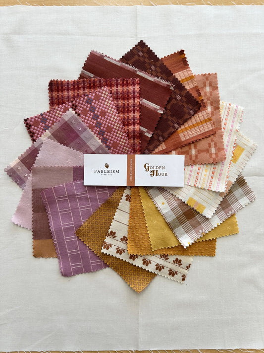 Golden Hour Charm Squares arranged in a colorful splay 