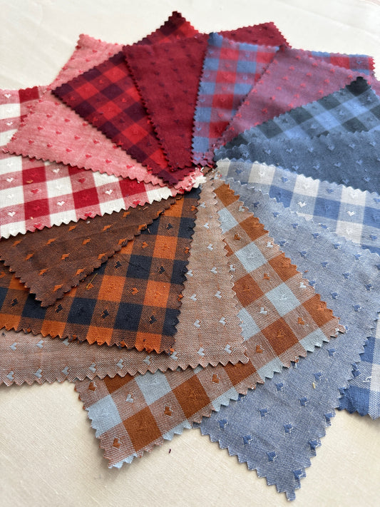 Queen of Hearts fabric close up featuring red, blue, brown and white fabric with checkered prints and tiny hearts 