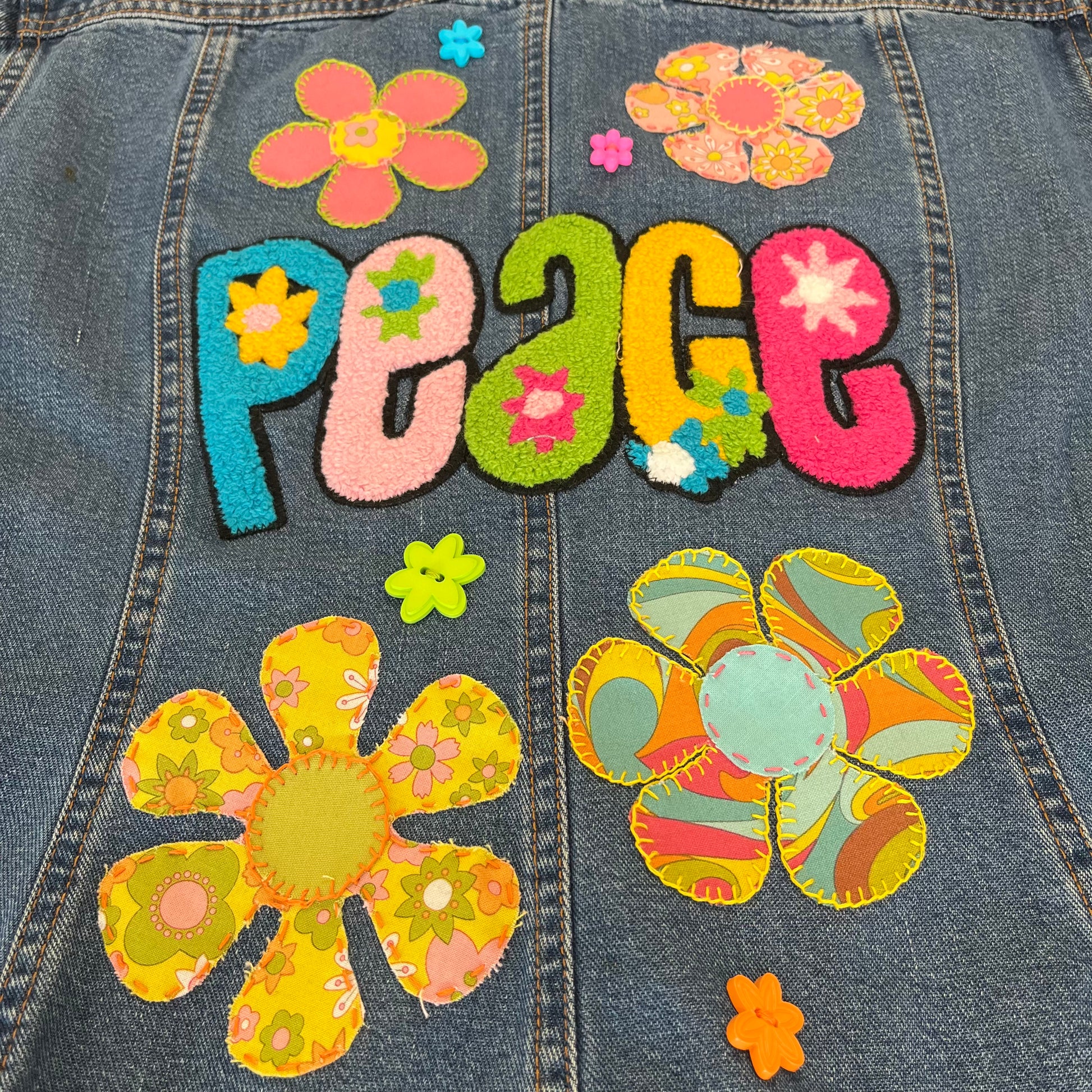 Denim jacket with colorful 'PEACE' patch and floral designs
