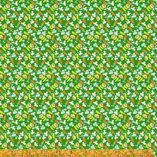 A calico fabric with small white flowers  with orange, blue and yellow accents, against a green background